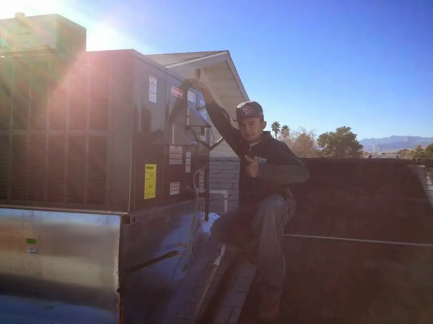 HVAC technician performing HVAC Inspection on a rooftop unit in Beachwood